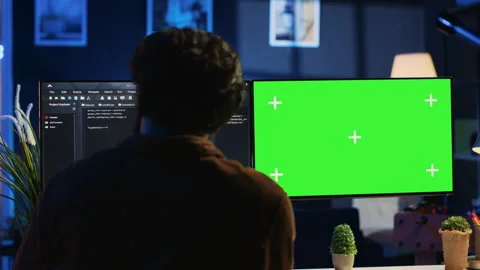 Programmer typing complex code on green screen computer in neon lit home office Stock Footage 265339232