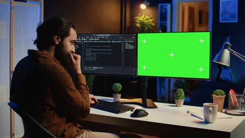 Programmer typing complex code on green screen computer in neon lit home office Stock Footage 265621930