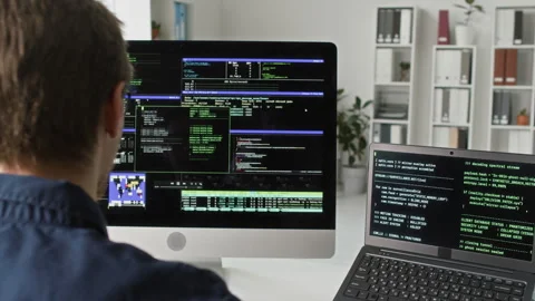 Programmer Typing on Computer Reviewing Code on Multiple Screens at Office Desk Video stock 330124363