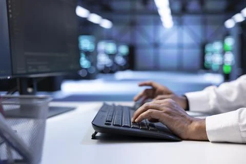 Programmer typing on keyboard, optimizing data center performance Stock Photos
