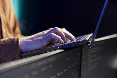 Programmer typing on laptop to fix system vulnerabilities, close up Stockfoto's