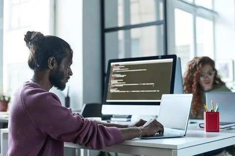 Programmer typing on laptop in IT office Stock Photos
