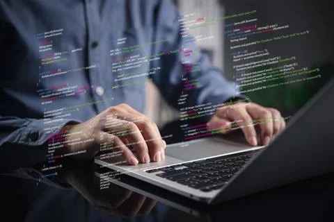 Programmer typing on laptop with virtual code overlay. Software development.. Stock-Fotos