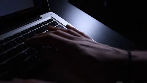 Programmer typing on a modern laptop computer at night pan and tilt shot Stock Footage 72076636