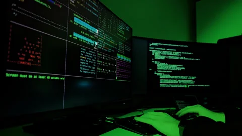 Programmer Typing Source Code on Multi Monitor Setup in Dark Green Office Room Stock Footage 306758666