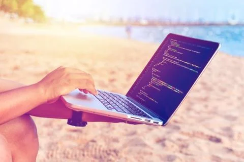 A programmer typing source codes at the beach in a relaxing working environme Stock Photos