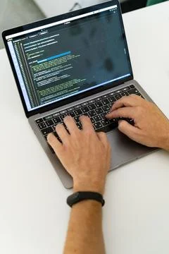 Programmer, typing with two hands, one of which is wearing a watch. Stock Photos