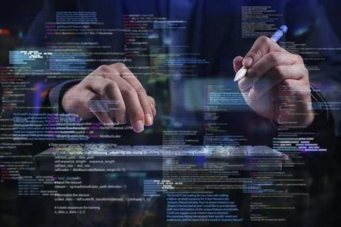 Programmer typing on virtual keyboard with glowing digital code overlay. Co.. Stock Photos