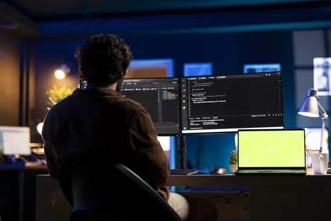 Programmer using green screen laptop to implement security measures Stock Photos