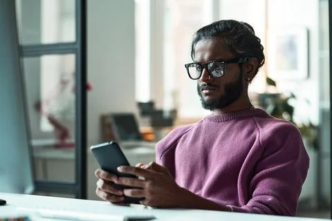 Programmer using mobile phone at his work Stock-Fotos