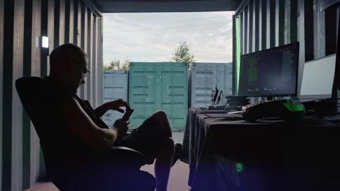 Programmer using a smartphone at diy workstation inside a container Stock Footage 341658970