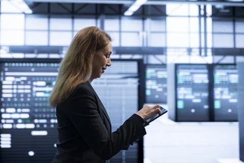Programmer using tablet in data center with advanced tech Stock Photos