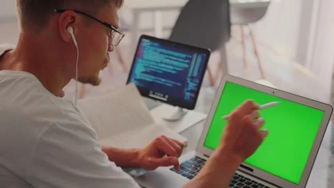 Programmer in video call, tablet shows code, discussing app interface. Stock-Footage 299895470