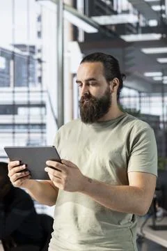 Programmer walking through office with tablet Stock Photos