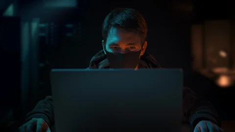  Programmer wearing mask working coding on computer late night in dark room Stock Footage 129386705