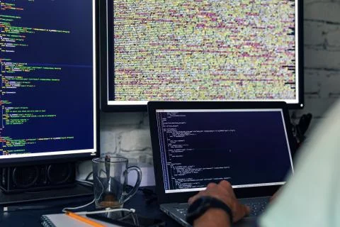 Programmer web developer working on multiple computers Stock Photos