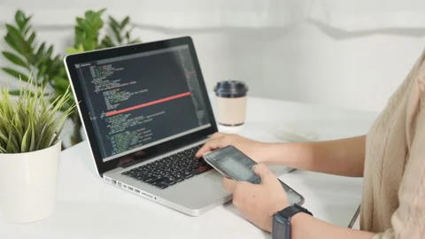 Programmer woman looking mobile phone program code at workplace Stock Footage 236242275