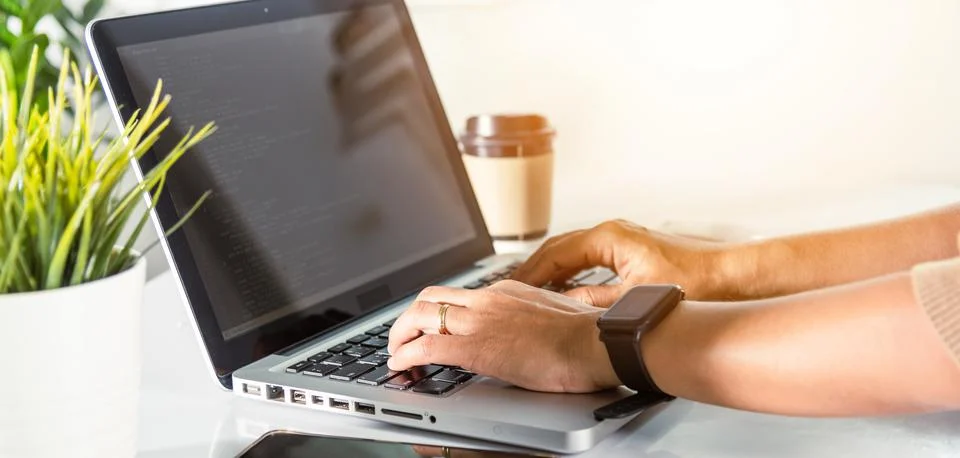 Programmer woman writing program code sitting at workplace in office Stockfoto's
