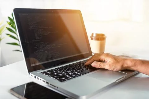 Programmer woman writing program code sitting at workplace in office Foto stock