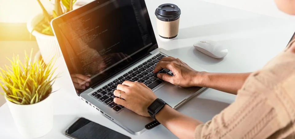 Programmer woman writing program HTML code sitting at workplace in office Stock Photos