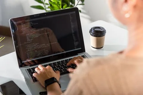 Programmer woman writing program HTML code sitting at workplace in office Stock Photos