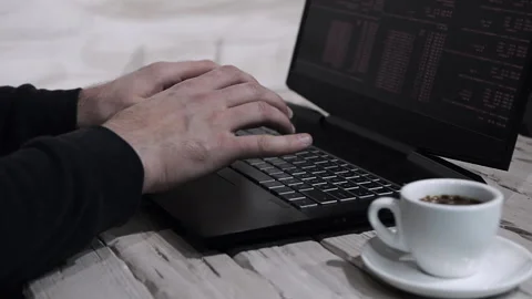 Programmer work at home. Man is typing on a laptop keyboard with a cup of coffee Stock-Footage 166247017