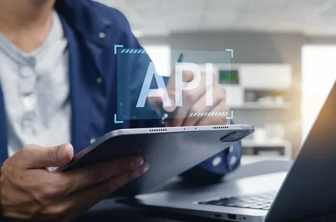 Programmer Working on API Interface Development with Tablet and Laptop Foto stock