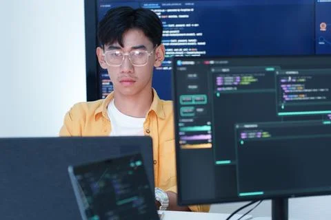 Programmer Working with Code on Multiple Computer Screens Fotos Stock