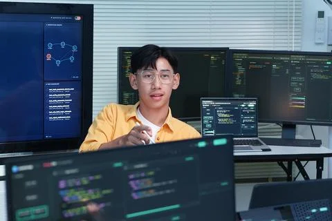 Programmer Working with Code on Multiple Digital Screens Stockfoto's