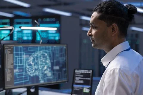 Programmer working on computer in data center with artificial intelligence Stock-Fotos