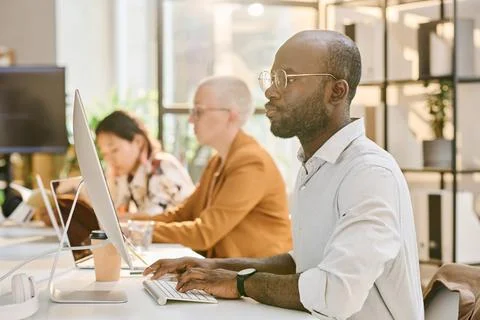 Programmer working on computer with his colleagues Stock Photos