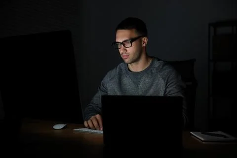 Programmer working on computer indoors at night Stock Photos
