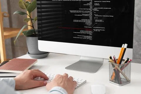 Programmer working with computer at white desk in office, closeup Stock Photos