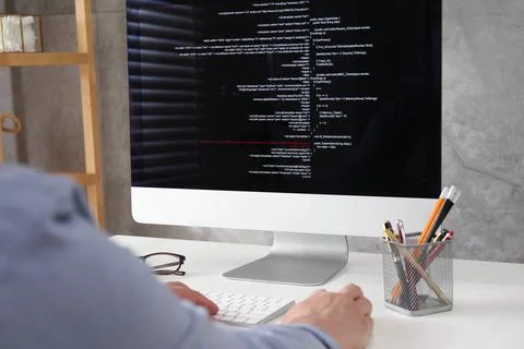 Programmer working with computer at white desk in office, closeup Foto stock