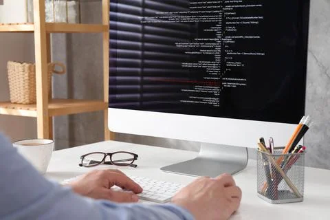 Programmer working with computer at white desk in office, closeup Stock Photos