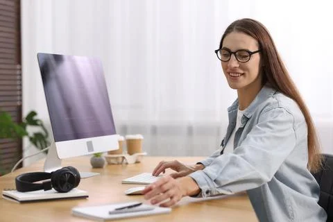 Programmer working on computer at wooden desk indoors 스톡 사진
