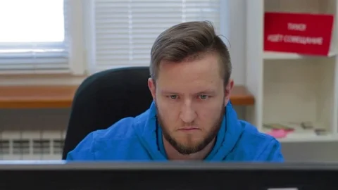 Programmer is working concerned on computer screen Video stock 73898657