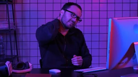 A programmer working on his computer having pain in his neck. Foto stock