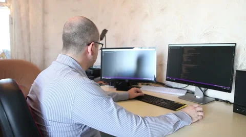 Programmer working at home sitting at the computer 스톡 동영상 64830616