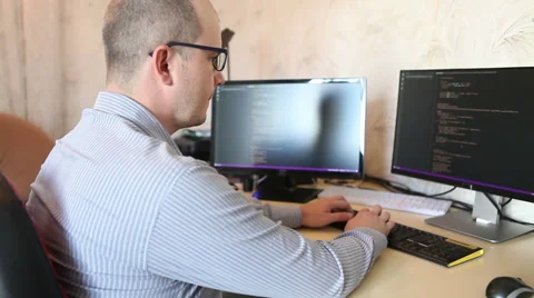 Programmer working at home sitting at the computer 스톡 동영상 64830675