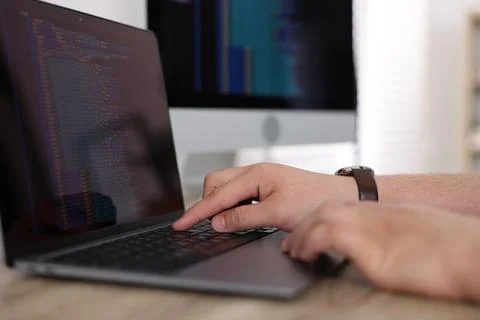 Programmer working with laptop at desk in office, closeup Foto stock