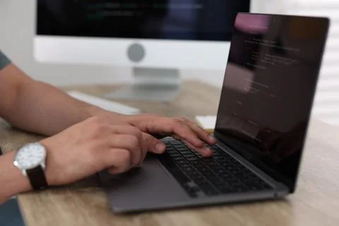Programmer working with laptop at desk in office, closeup Foto stock