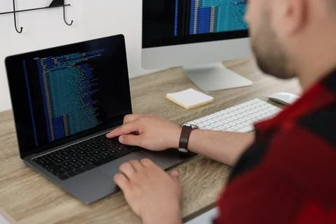 Programmer working with laptop at desk in office, closeup 写真素材