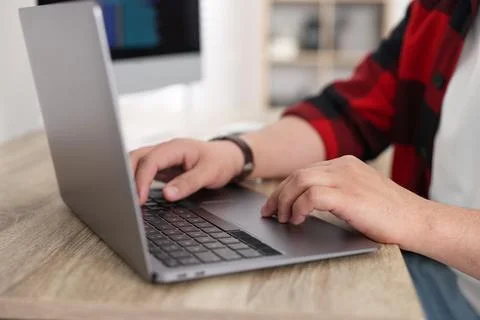 Programmer working with laptop at desk in office, closeup 写真素材