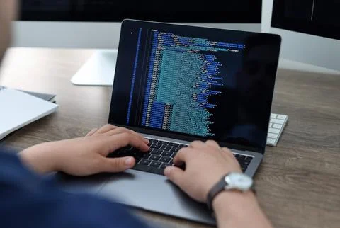 Programmer working with laptop at desk in office, closeup 写真素材