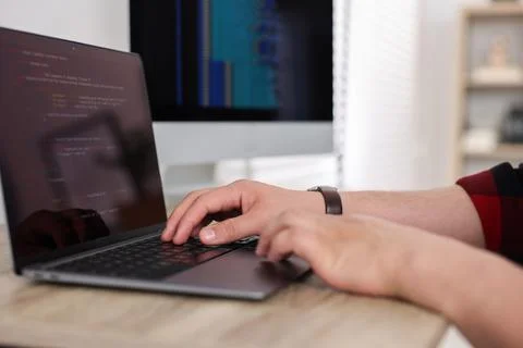 Programmer working with laptop at desk in office, closeup 写真素材
