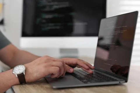 Programmer working with laptop at desk in office, closeup 写真素材