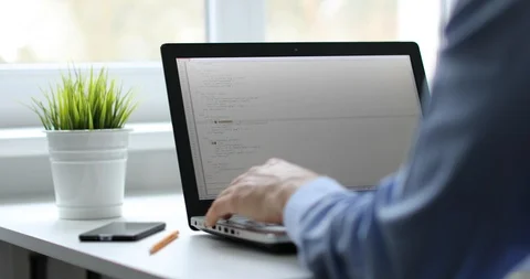 Programmer working on laptop in office writing programming code Stock Footage 85600664