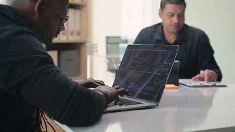 Programmer Working on Laptop Sitting at Same Desk with Manager Video stock 252569526