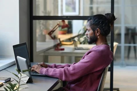 Programmer working on laptop at table Stock Photos